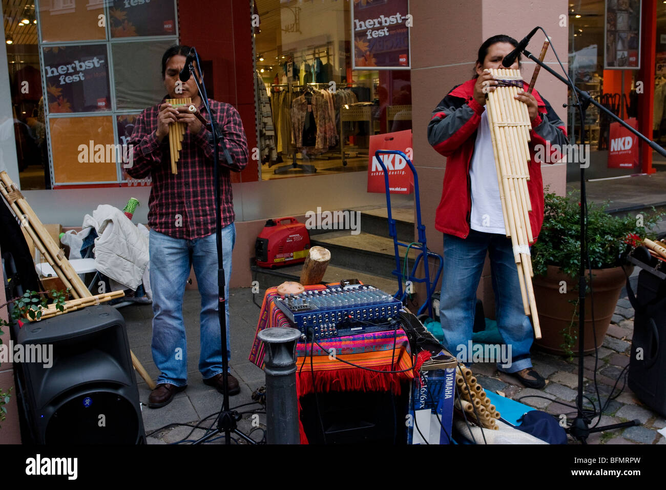 Two south American musicians play pan flutes during a festival in