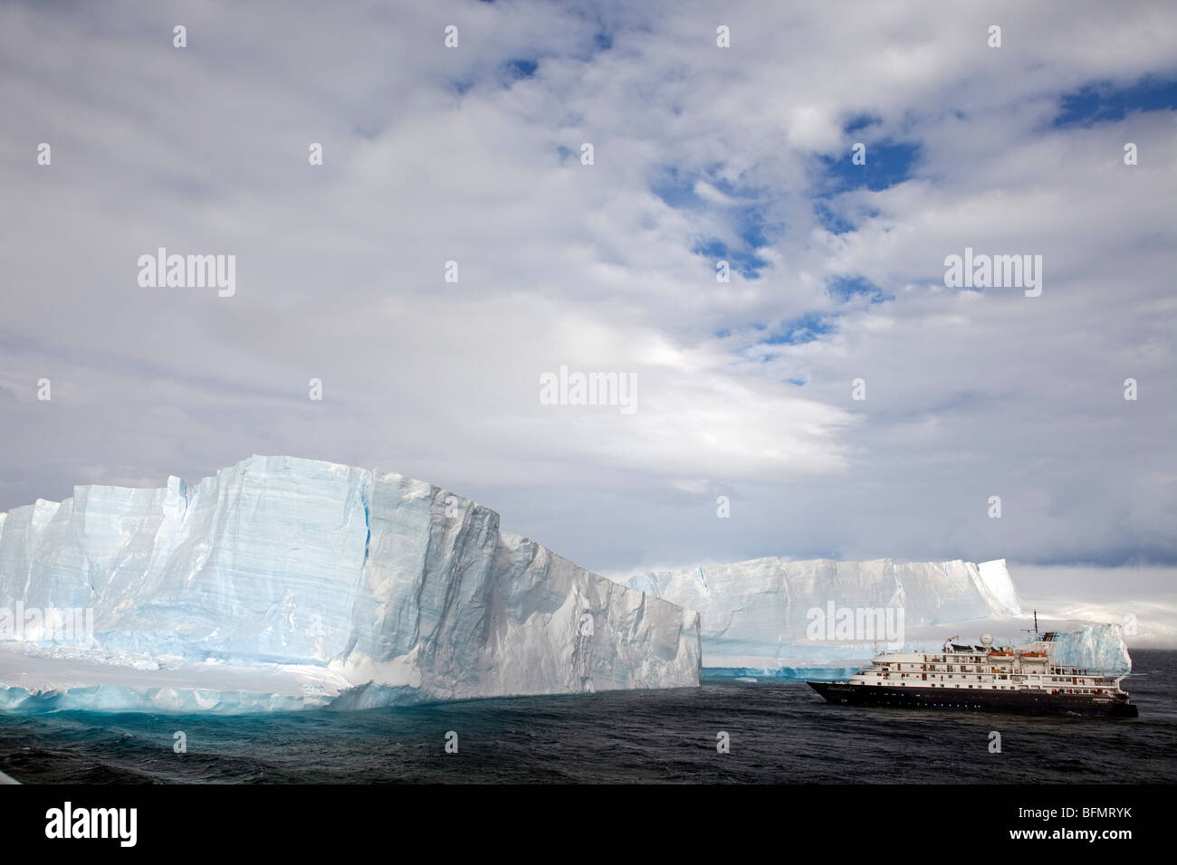 Antarctica, Antarctic Sound and Hope Bay, expedition ship the Corinthian III is dwarfed by the tabular icebergs. Stock Photo