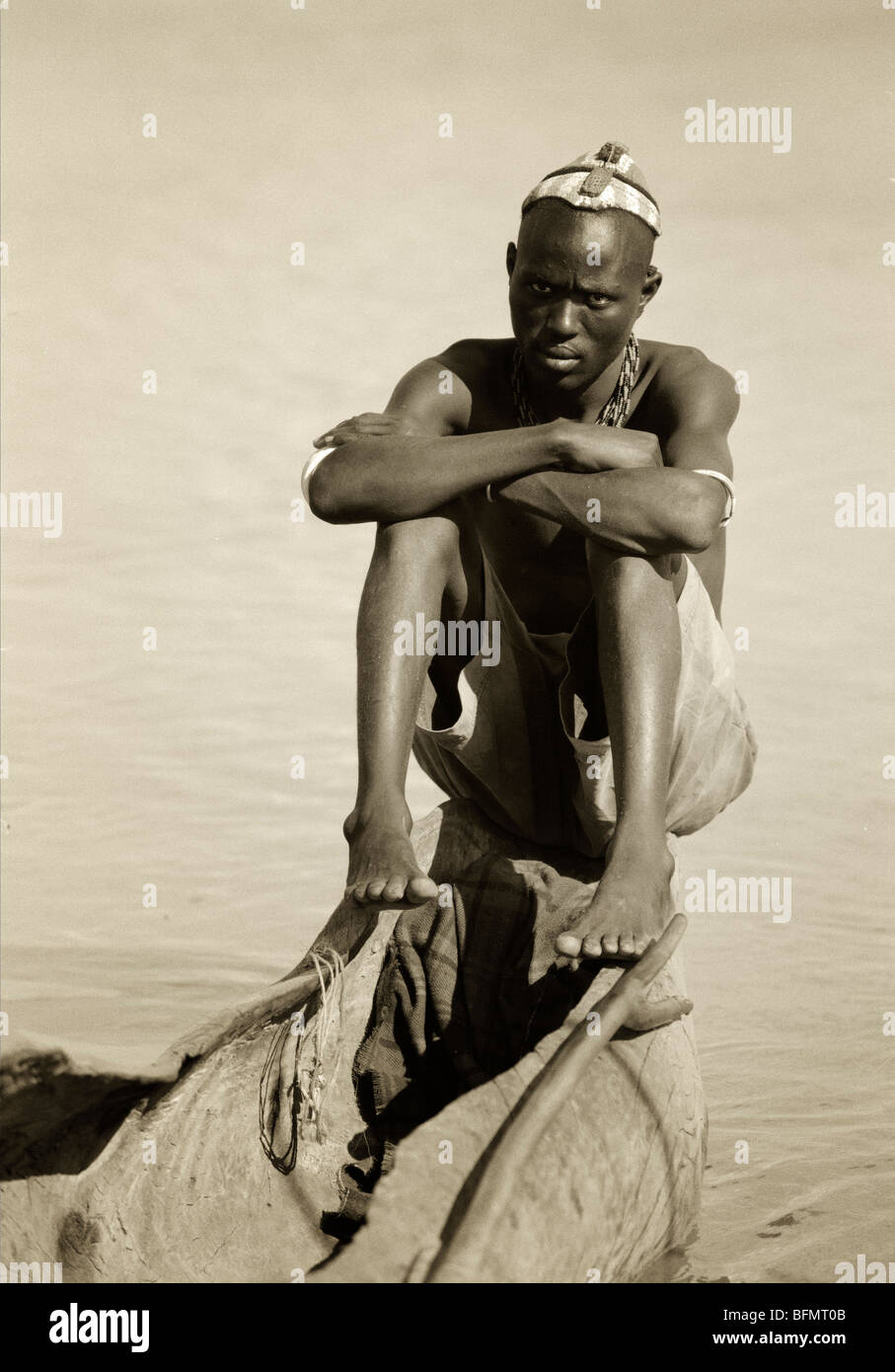 Kenya, Lake Turkana.  An El Molo fisherman sits in his dugout canoe on the fringe of the Omo Delta. Stock Photo