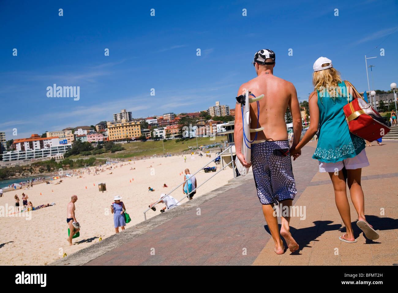 Australia, New South Wales, Sydney.  A young couple walk along the promenade at Bondi Beach. Stock Photo