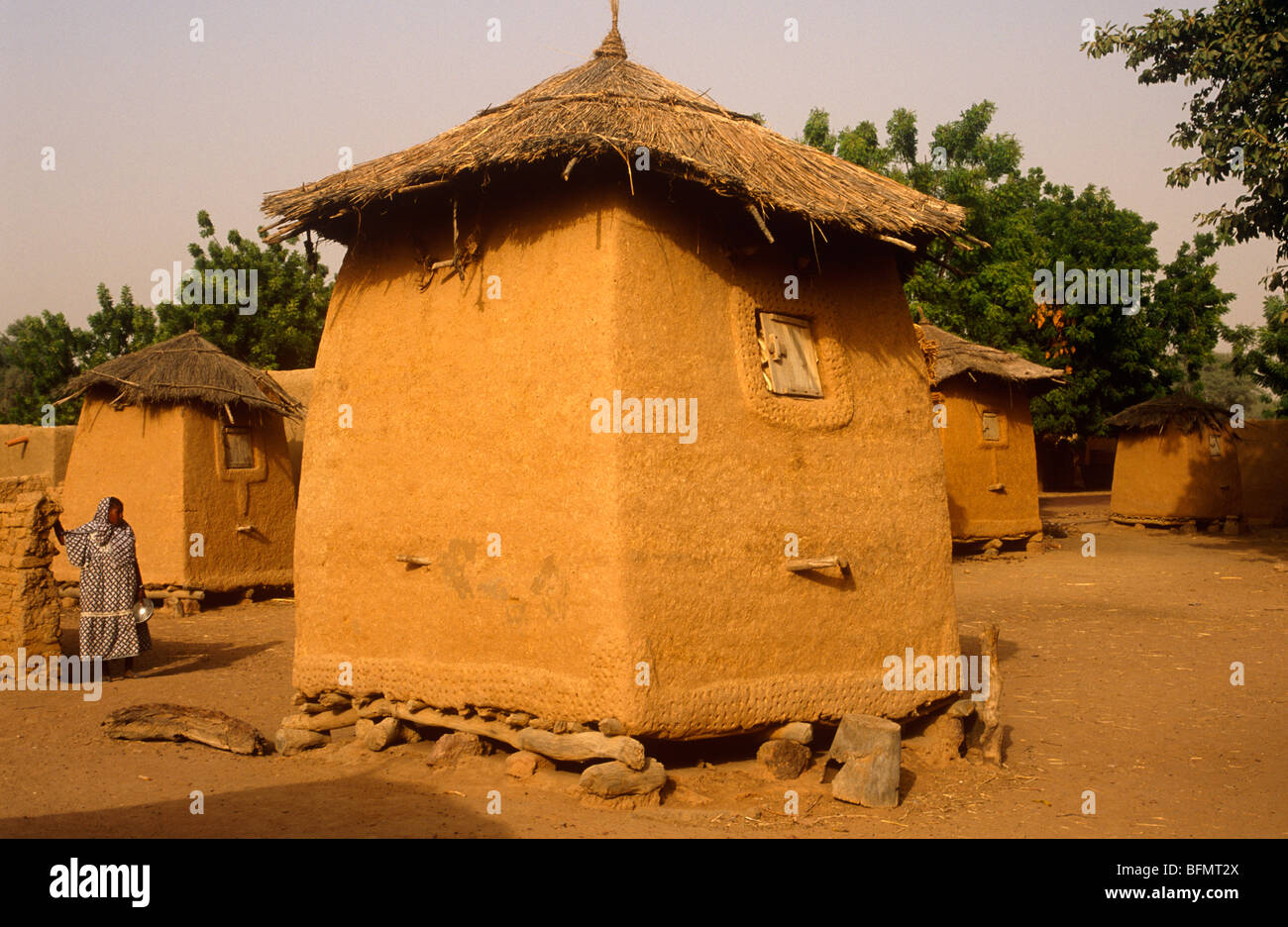 Mali, Promani village, near Djenne. Villagers pause beside a small mud ...