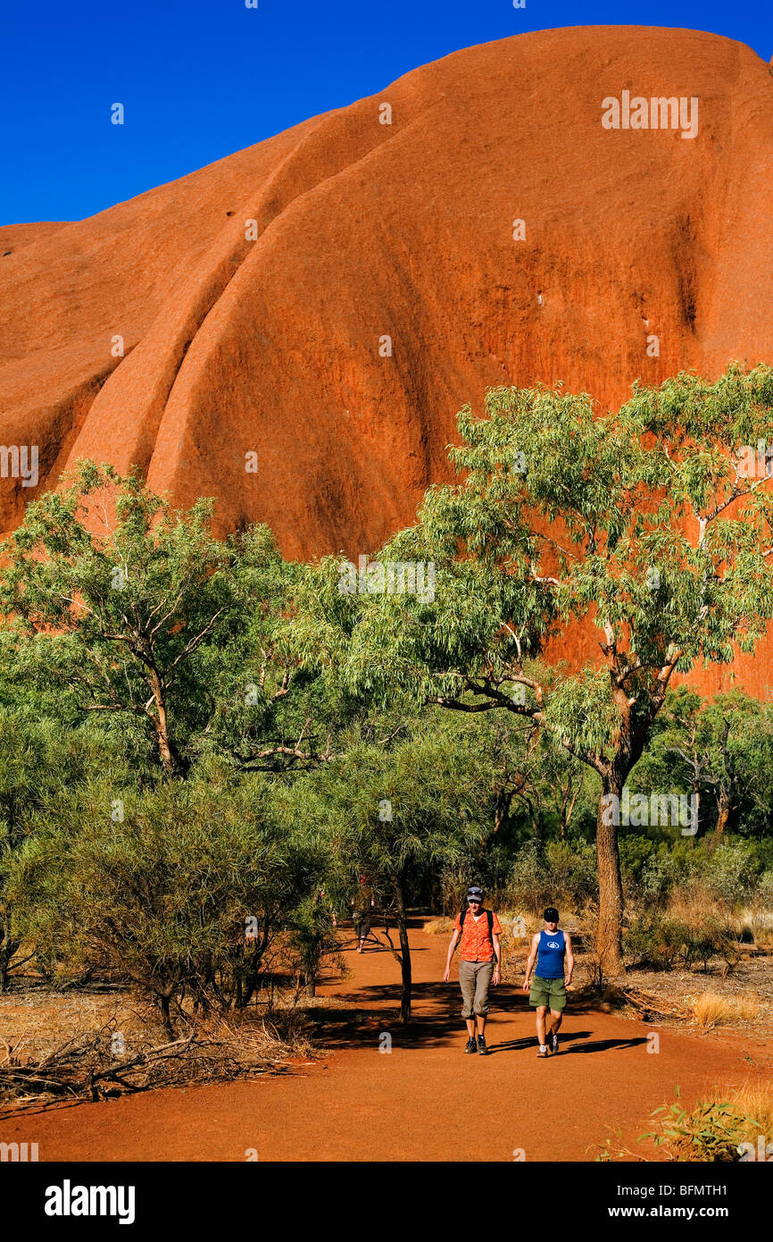 Australia, Northern Territory, Uluru-Kata Tjuta National Park.  Hikers on the base walk at Uluru (Ayers Rock).   (PR) (MR) Stock Photo