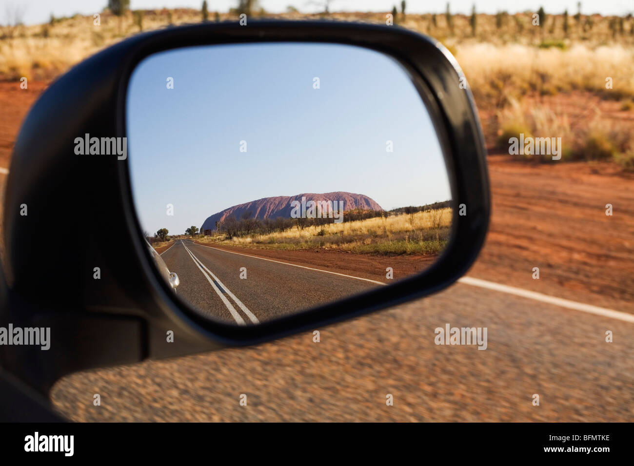 Australia, Northern Territory, Uluru-Kata Tjuta National Park.  Uluru (Ayers Rock) in the rear vision mirror.   (PR) Stock Photo