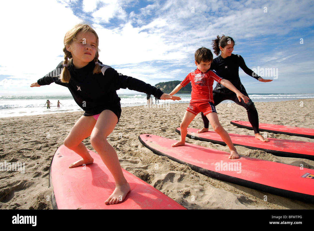 New Zealand, North Island, Coromandel Peninsula. Family surf lesson with Ricky Parker of Whangamata Surf School. (MR) Stock Photo