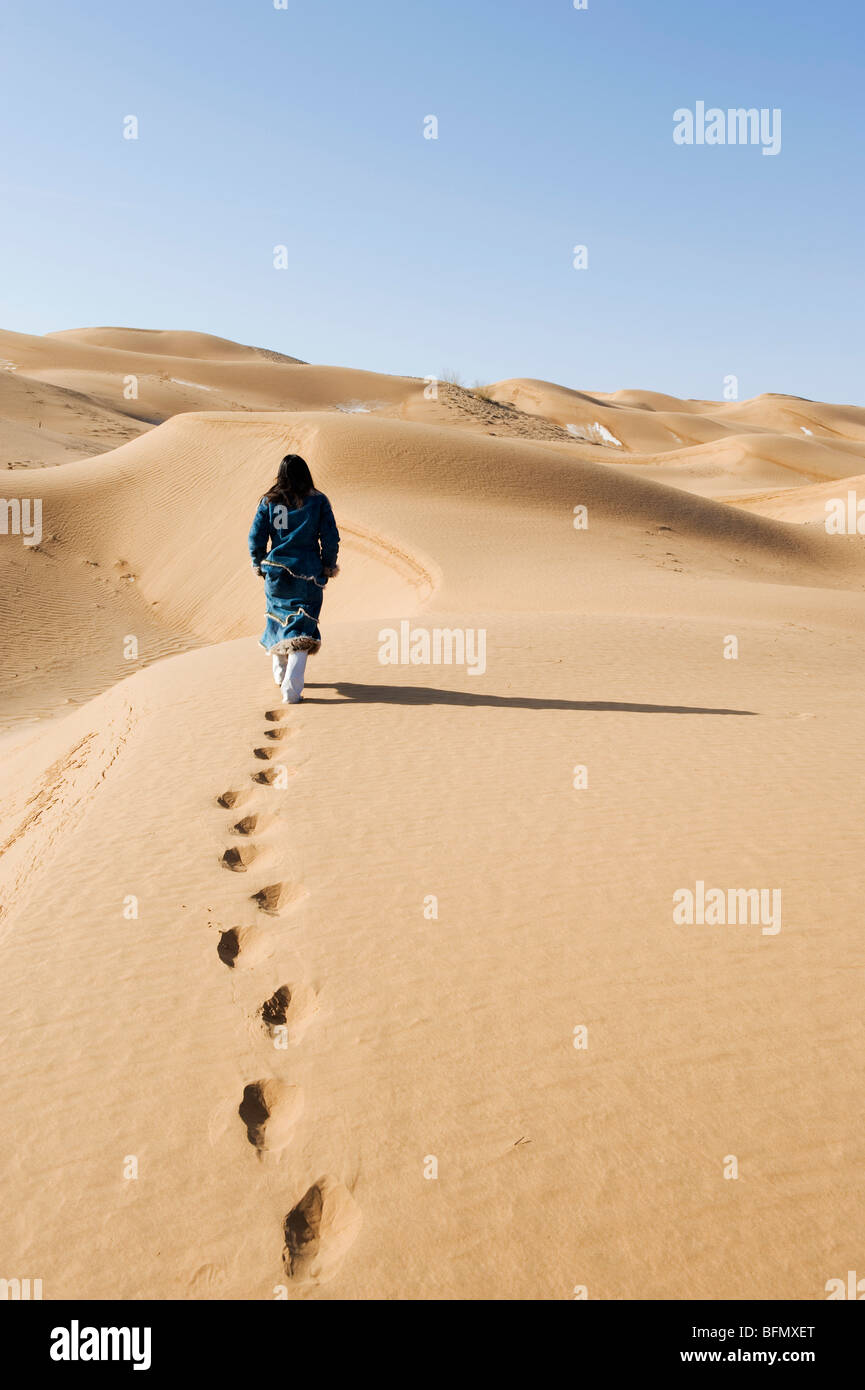 China, Ningxia Province, Shapotou, a girl walking in the sand, Tengger desert sand dunes (MR) Stock Photo