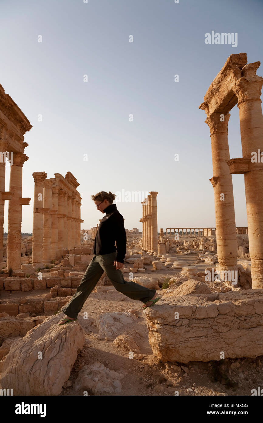 Syria, Palmyra. A tourist walks amongst the ancient ruins of Queen ...