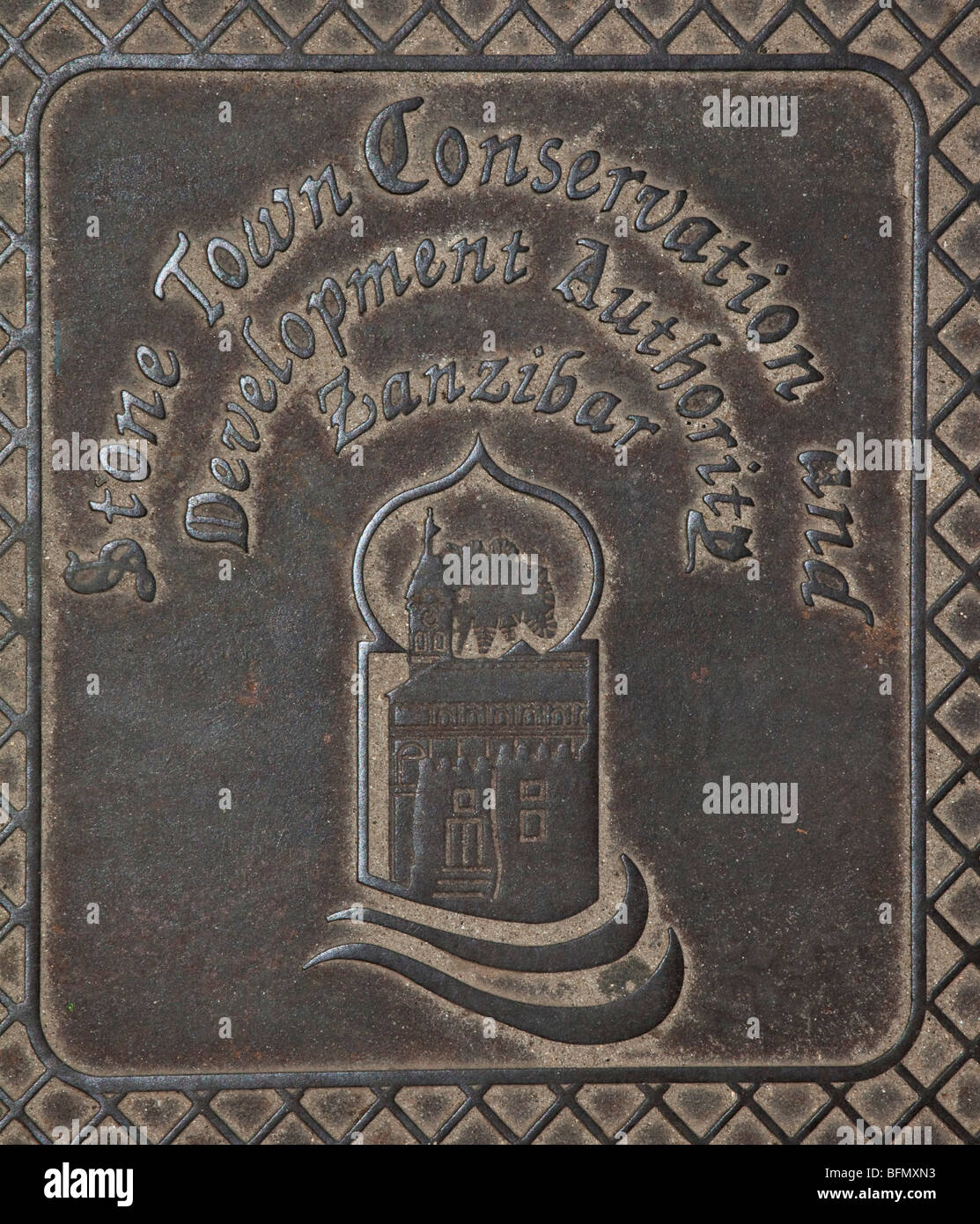 Tanzania, Zanzibar, Stone Town. A manhole cover in Stone Town highlighting the important contribution made by the Aga Khan Trust Stock Photo