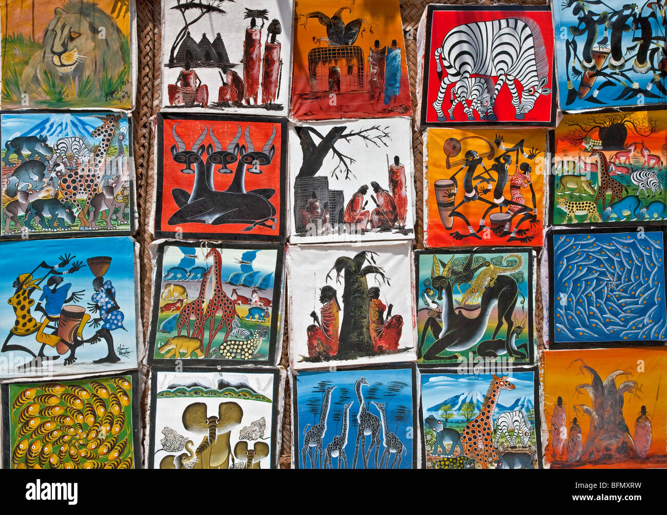 Tanzania, Zanzibar. Colourful paintings by local artists on sale near Paje Beach in the southeast of the island. Stock Photo