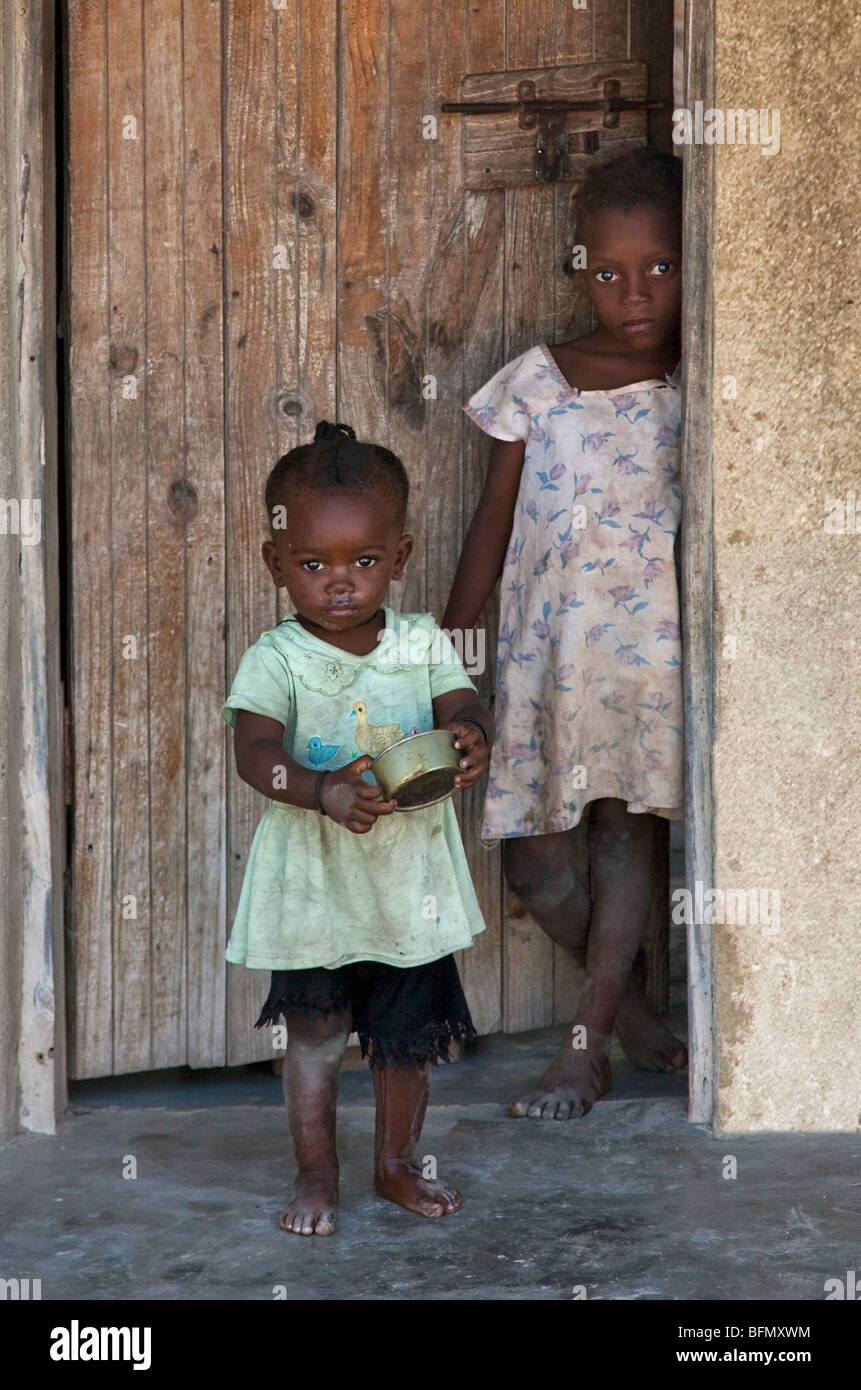 Tanzania, Zanzibar. Two young girls at the door of their house in Jambiani village. Stock Photo