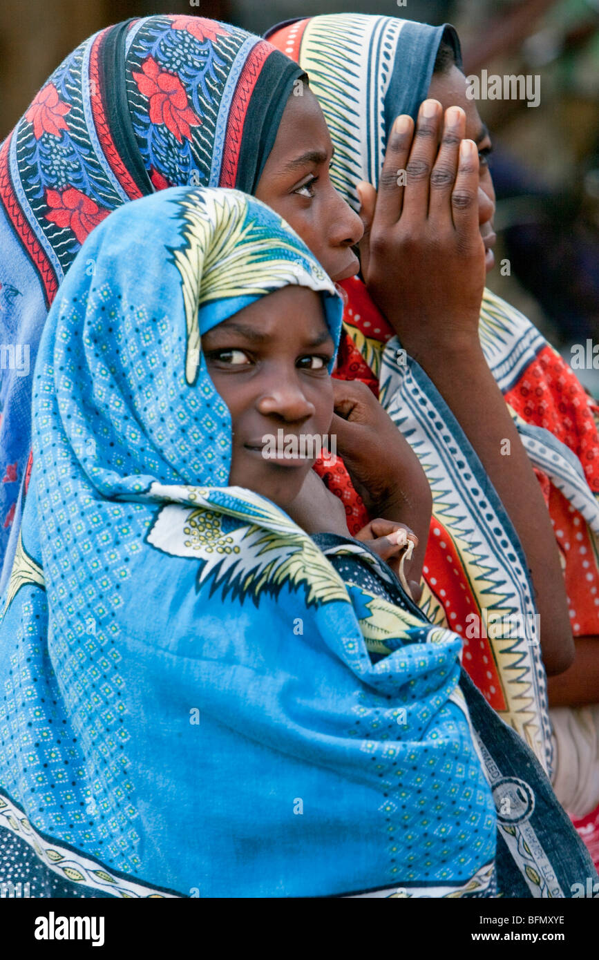 Tanzania, Zanzibar. Girls in brightly coloured cotton cloths, known as kangas, at Mkokotoni Market in northwest Zanzibar Island. Stock Photo