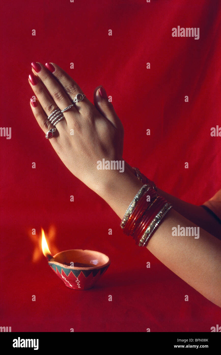 BDR 60856 : Diwali deepawali festival ; indian woman in Namaskar and deepak oil lamp on red background Stock Photo