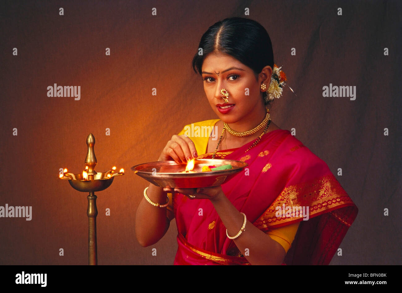 Diwali festival ; woman lighting oil lamp ; Bombay ; Mumbai