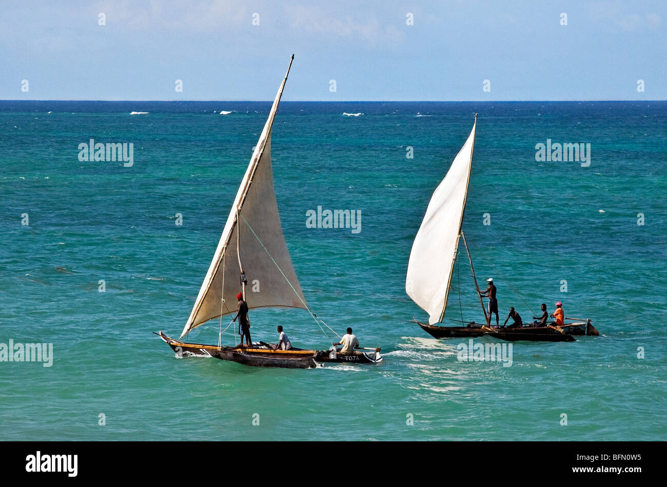 Kenya, Mombasa. Two outrigger canoes sail in the clear waters of the Indian Ocean, off Diani Beach. Stock Photo