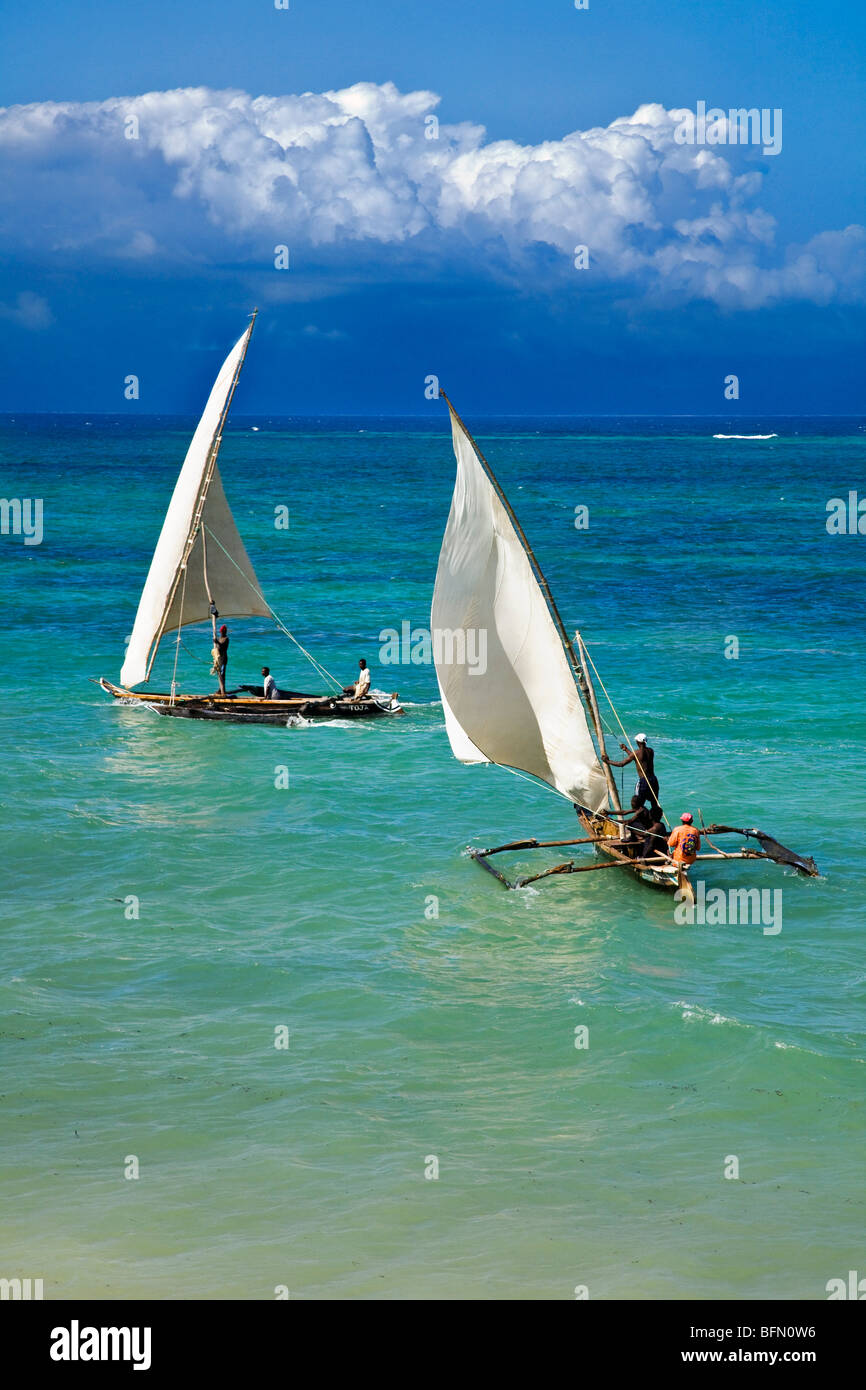 Kenya, Mombasa. Two outrigger canoes sail in the clear waters of the Indian Ocean, off Diani Beach. Stock Photo