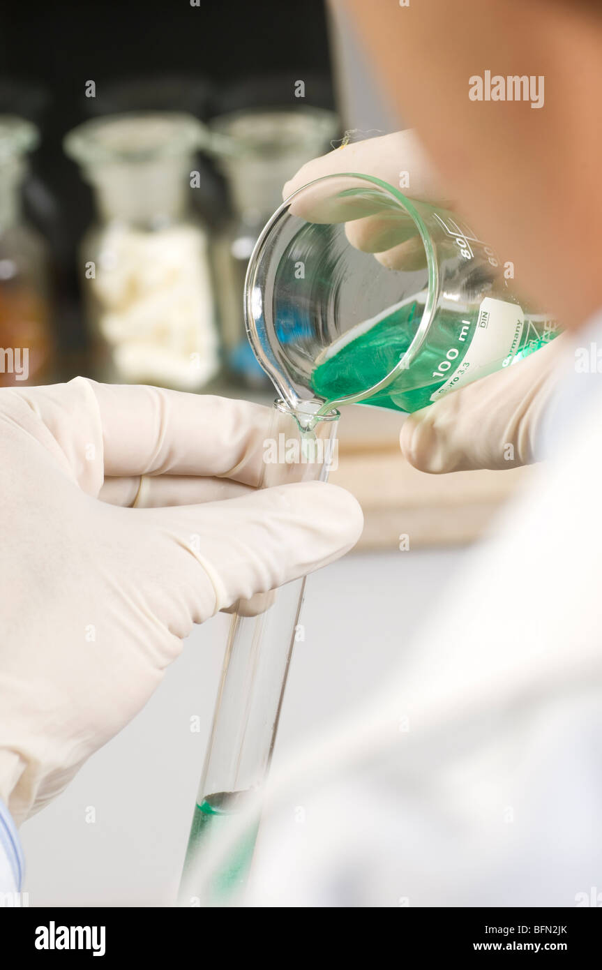 Scientist mixing solutions in test tubes Stock Photo