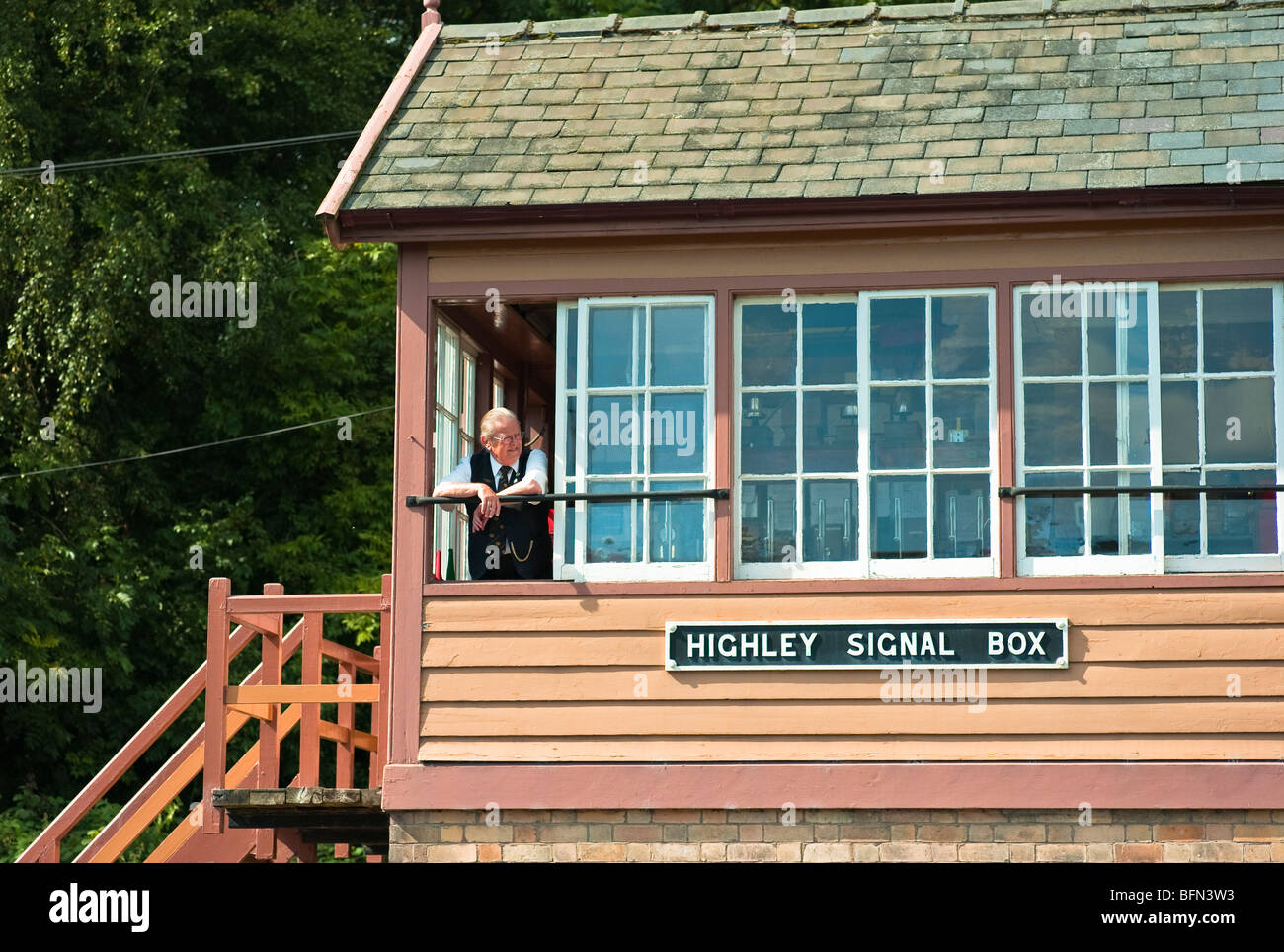Old railway signal box at Highley on the Severn Valley Railway with volunteer signalman checking the line Stock Photo