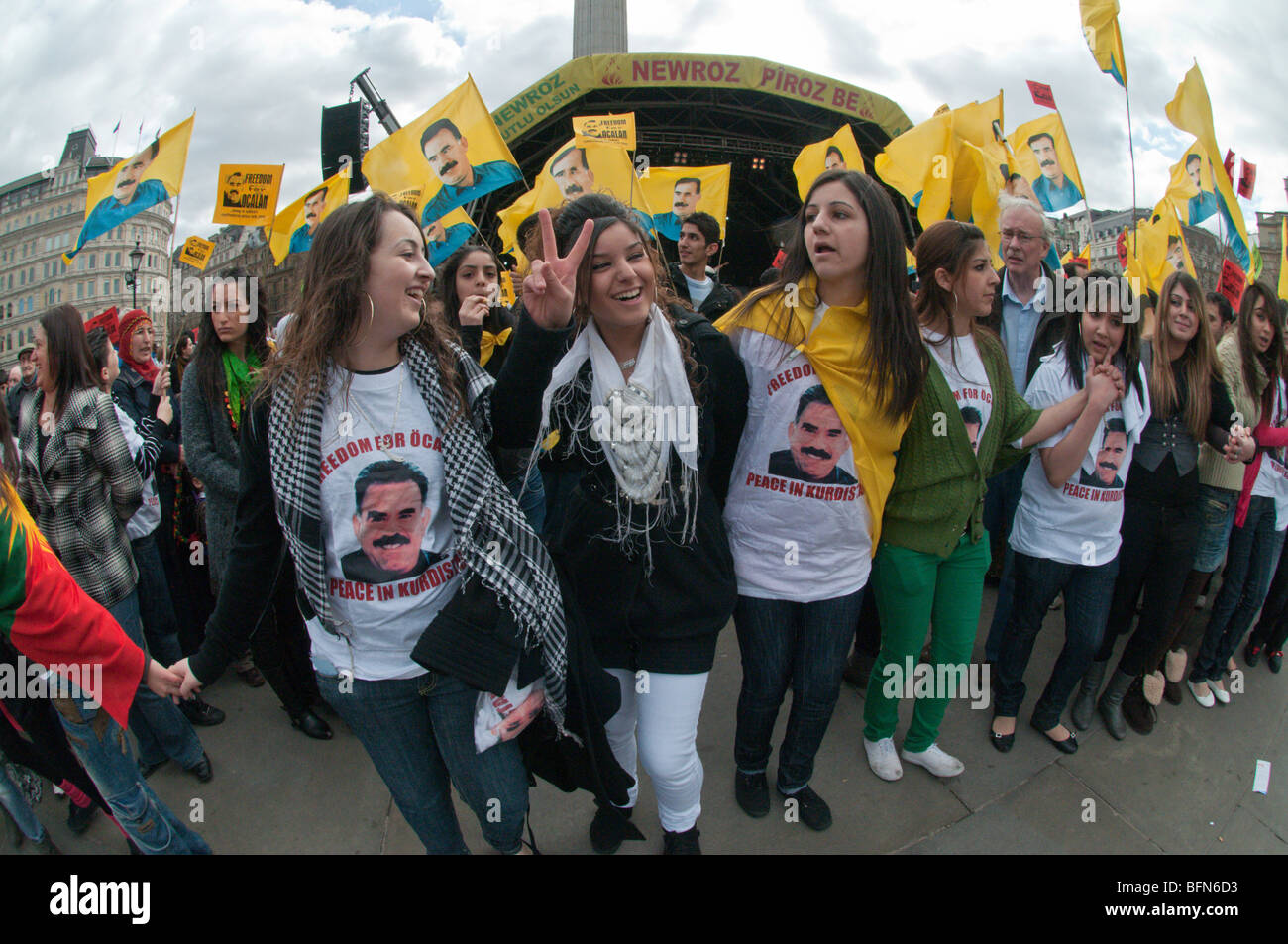 Celebrating Newroz the Kurdish New Year - banned in Turkey - in London, Girls in Free Ocalan t-shirts & crowd with flags Stock Photo