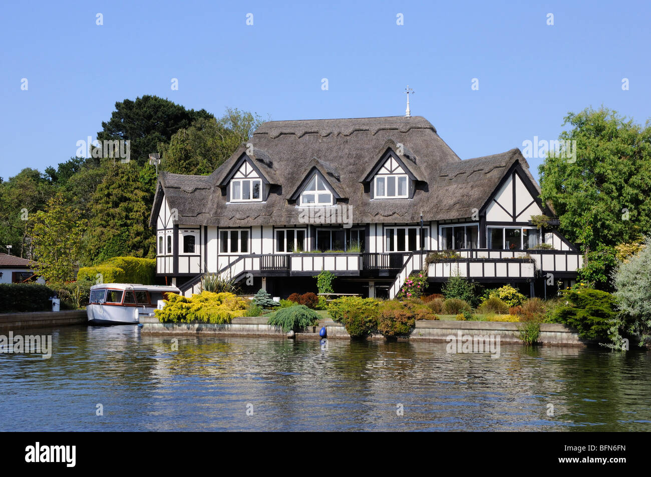 A thatched house by the river Bure in Horning, Norfolk Broads Stock