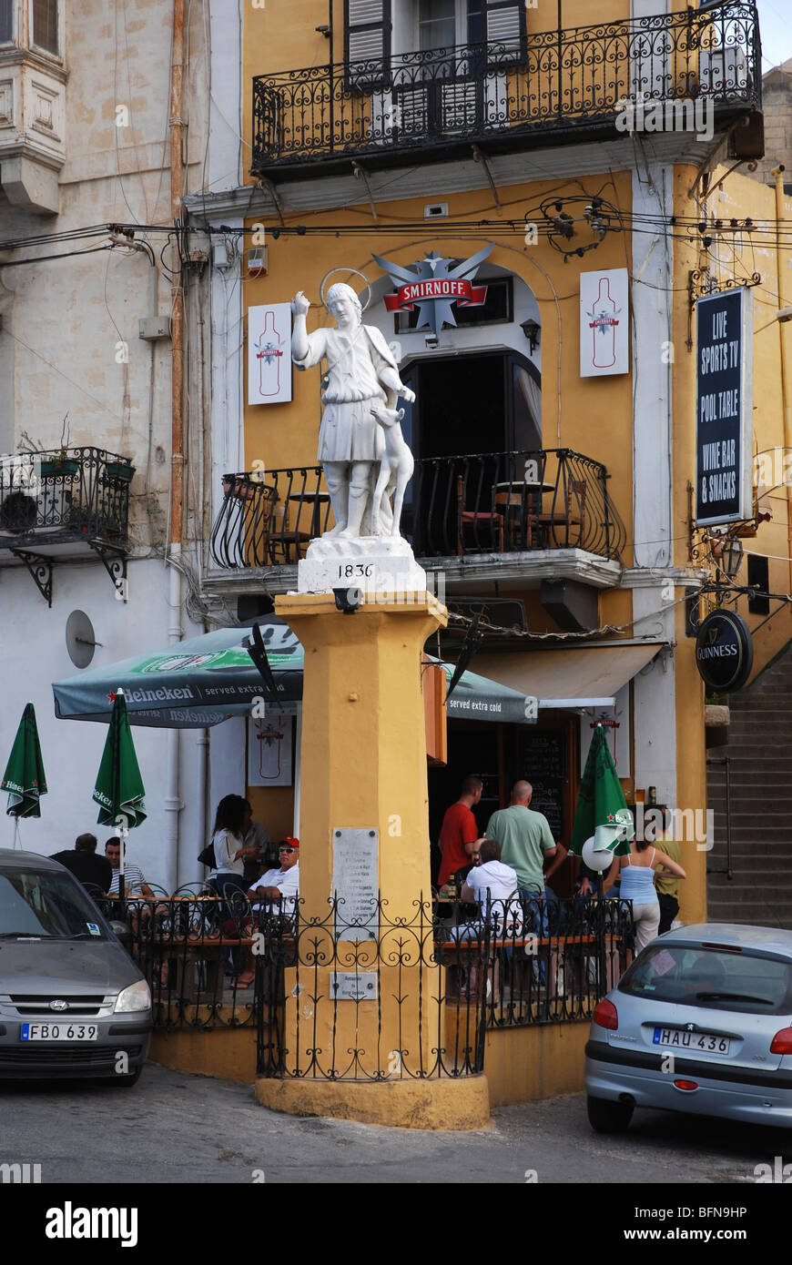 Column with statue in front of bar in St Julians Malta Stock Photo Alamy