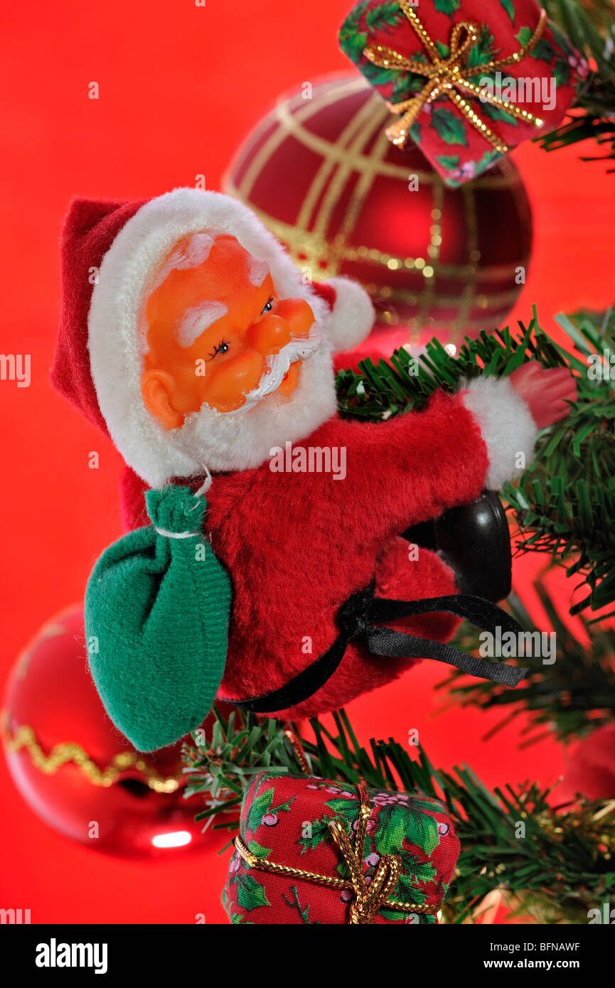 Santa Claus / Father Christmas and bells hanging in tree Stock Photo