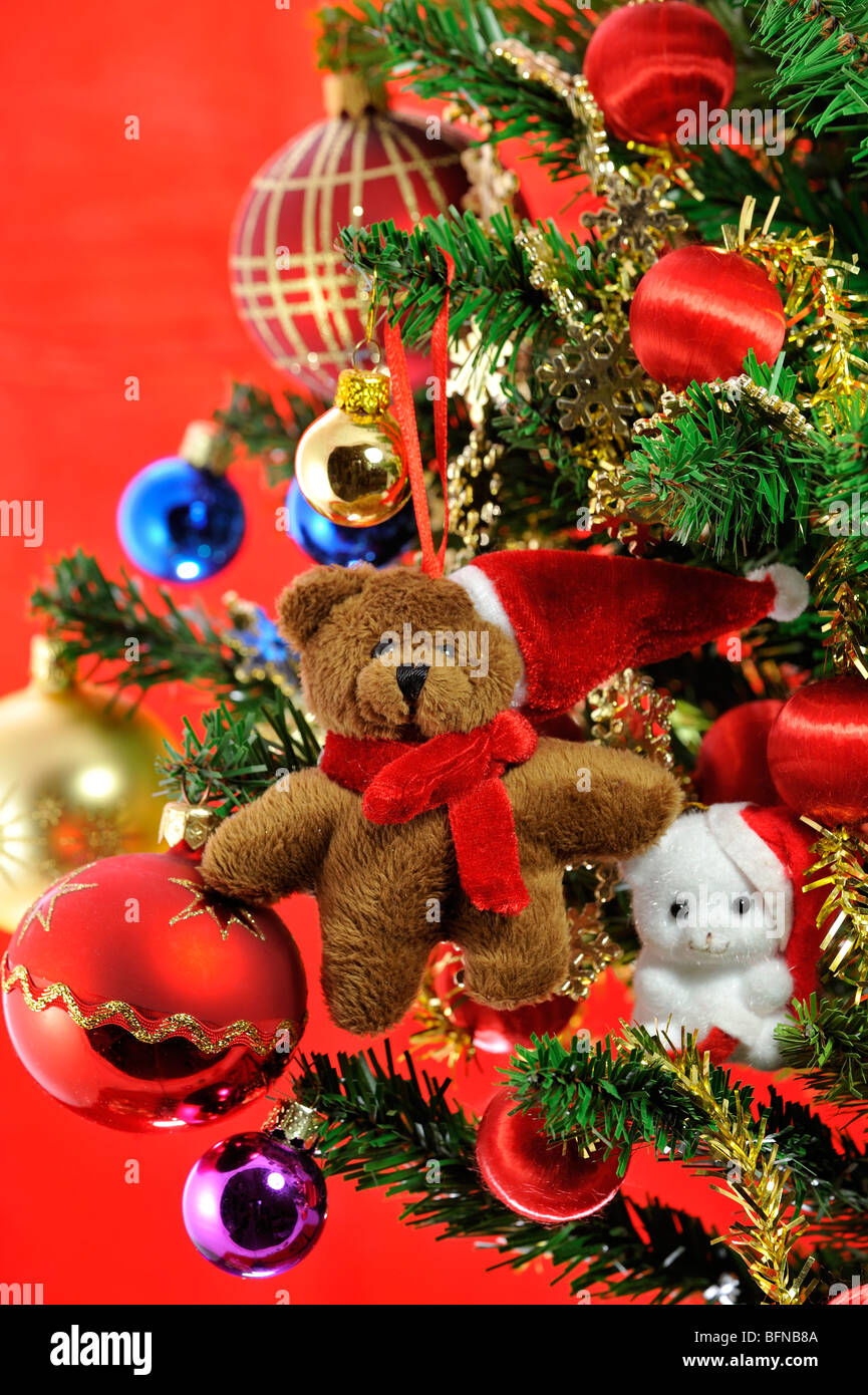 Teddy bear doll with pointed cap and bells hanging in Christmas tree Stock Photo