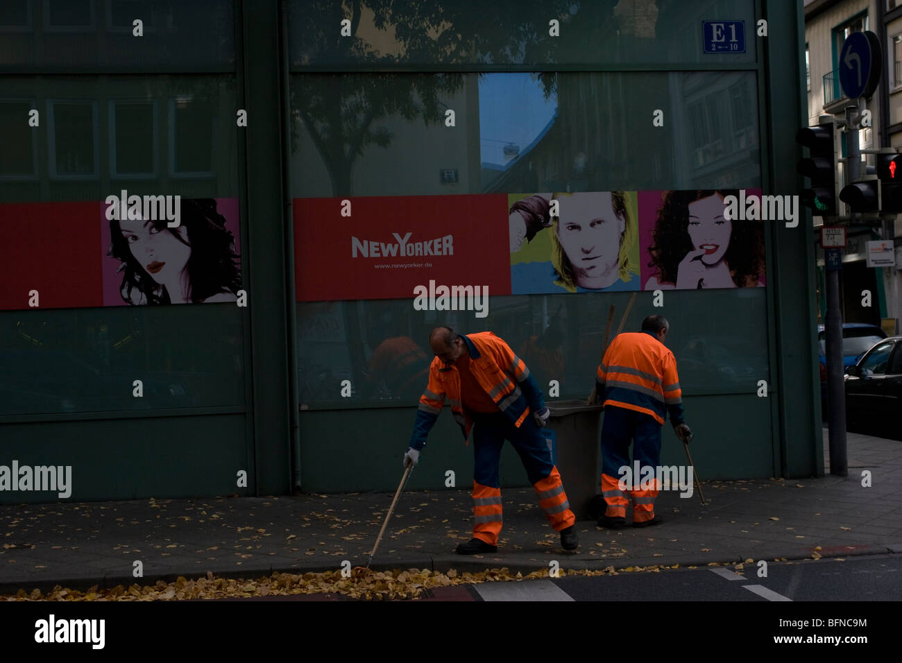Street cleaners gather autumn leaves of a street in front of the New