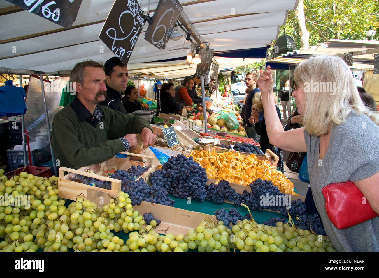 People shopping for produce at an outdoor Saturday market in Paris, France. Stock Photo