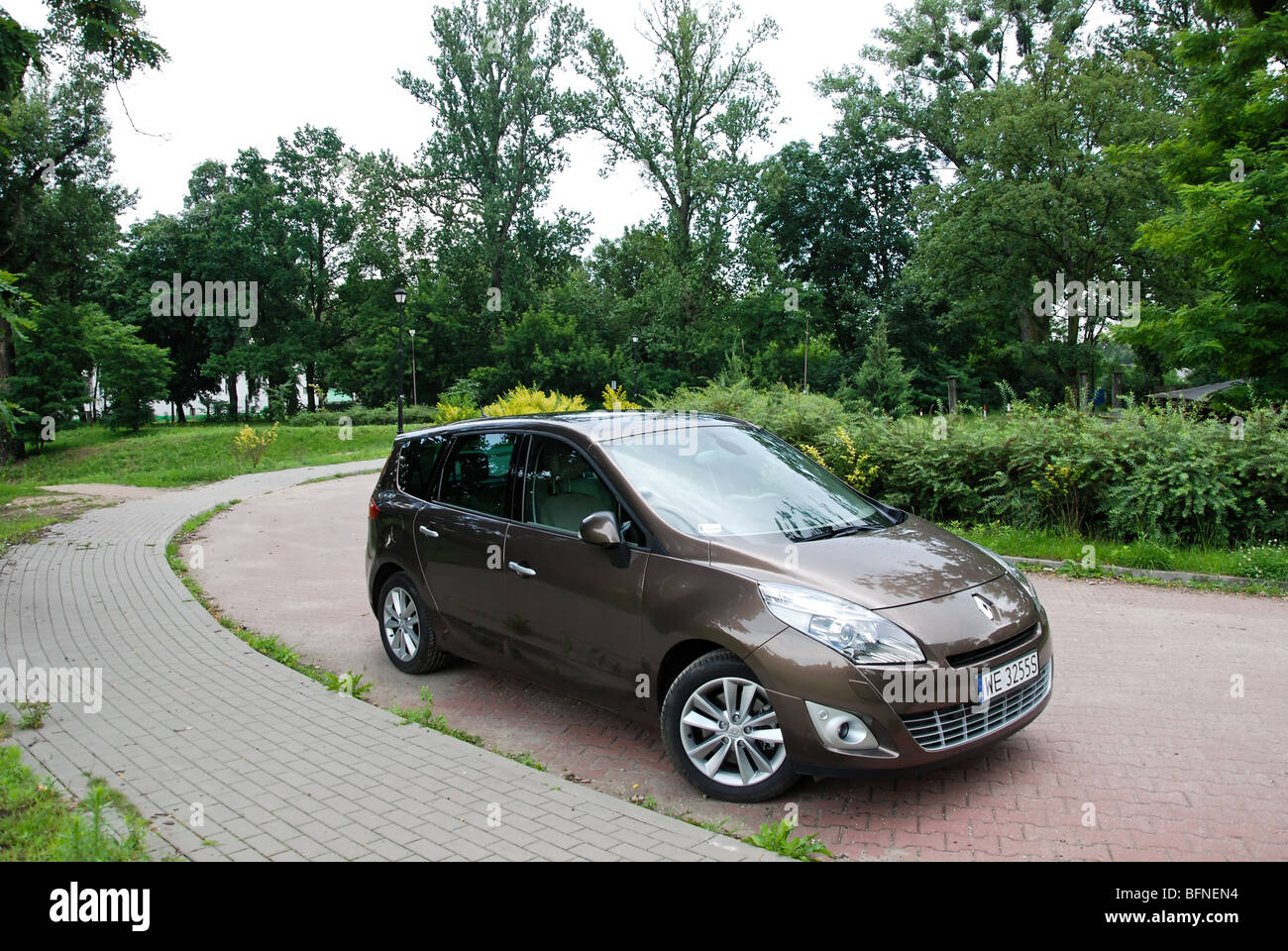 Renault Grand Scenic 1.9 dCi - 2009 - brown metallic - five doors (5D) -  French compact van (MPV) -  small street in a park Stock Photo