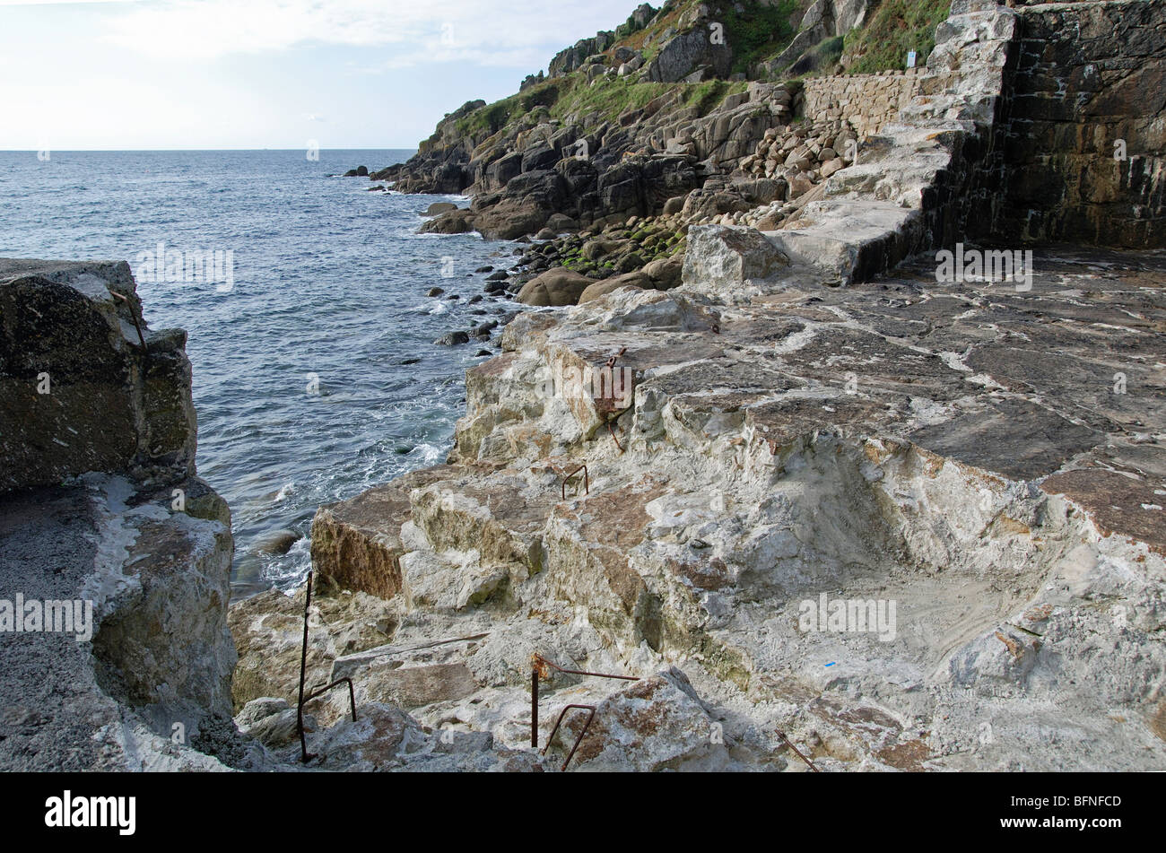 the damaged harbour  wall at lamorna cove in cornwall, uk ,  the damage has occured during recent high stormy seas Stock Photo