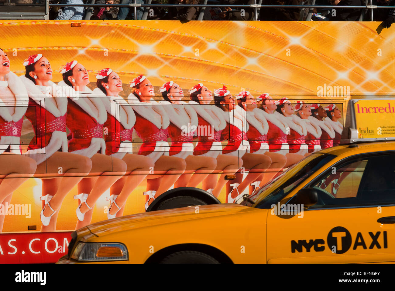 Taxi passes a tour bus with an advertisement for the Radio City Music Hall Christmas Spectacular with the Rockettes in New York Stock Photo