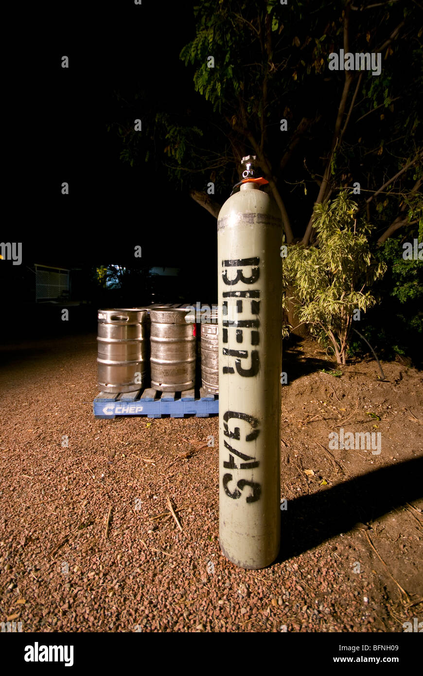 A cylinder contains gas for a pubs beer supply rests with empty kegs