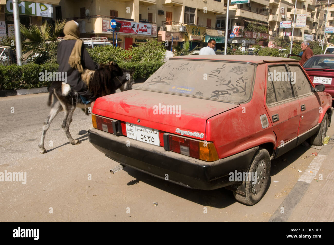 A car parked in Luxor city centre is covered in sandy dust. Stock Photo