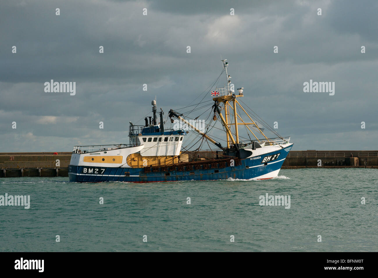 A trawler heading out towards Shoreham harbour entrance. Stock Photo