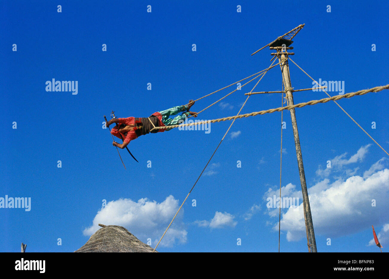Acrobatics ; woman revolving around pole with sword in mouth ; Jaipur ; Rajasthan ; India ; asia Stock Photo
