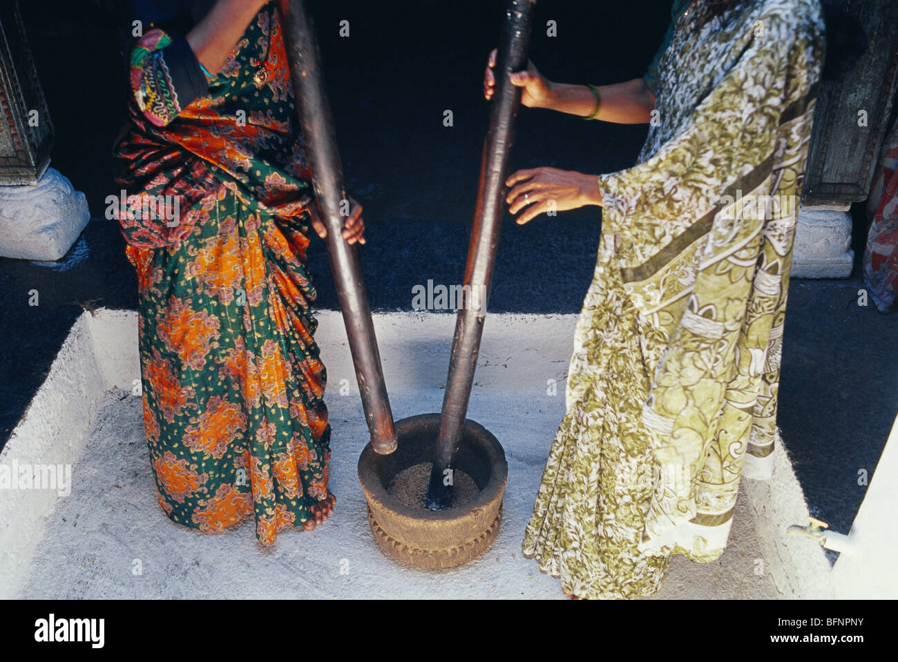 Women pounding rice ; Karnataka ; India ; asia Stock Photo