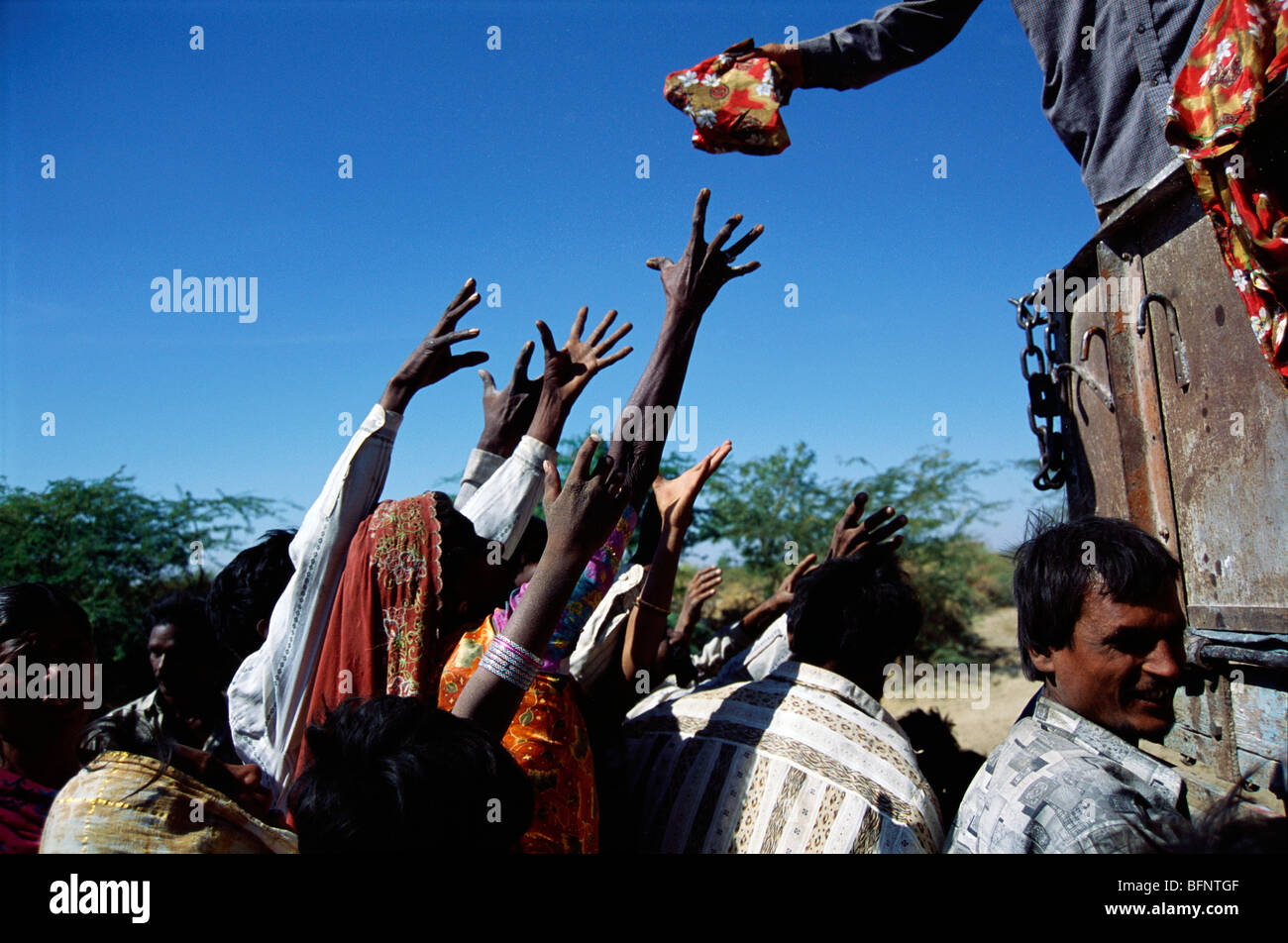 Earthquake victims raise hands to grab food packets ; free food distribution ; Kutch ; Bhuj ; Gujarat ; India ; asia Stock Photo