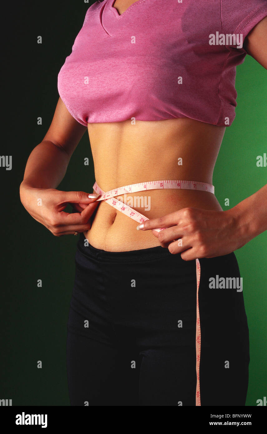 Indian teenager measuring waist with measurement tape ;  MR#442 Stock Photo