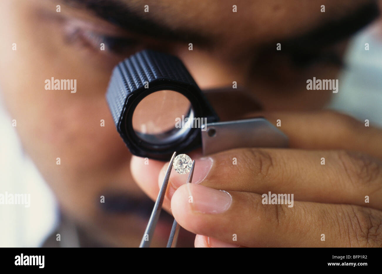 Man checking diamond through magnifying glass ; India ; asia Stock Photo