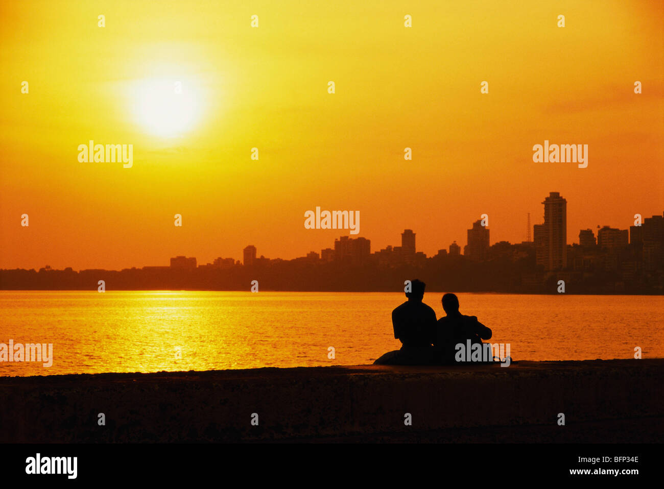 AHP 63335 : Couple romancing on Marine Drive at sunset ; Bombay Mumbai ; Maharashtra ; India Stock Photo