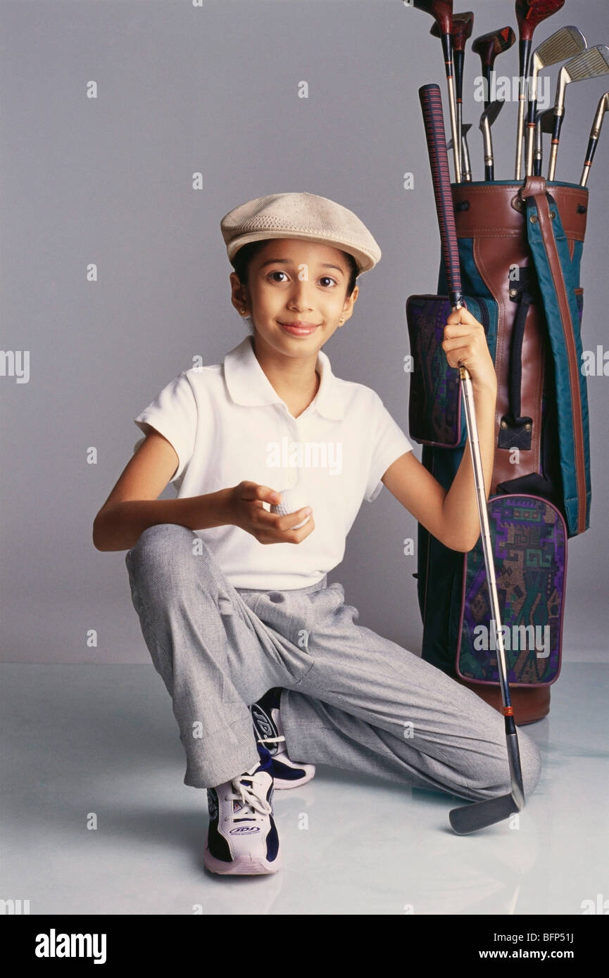 VDA 63734 : Girl dressed as golfer holding ball in hand with bag and golf clubs MR#329 Stock Photo