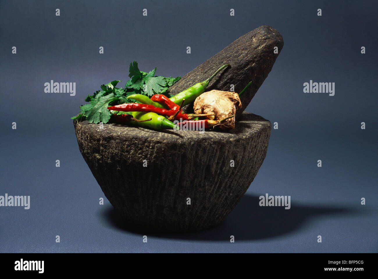 Indian spices in mortar to grind with pestle to make chutney ; India