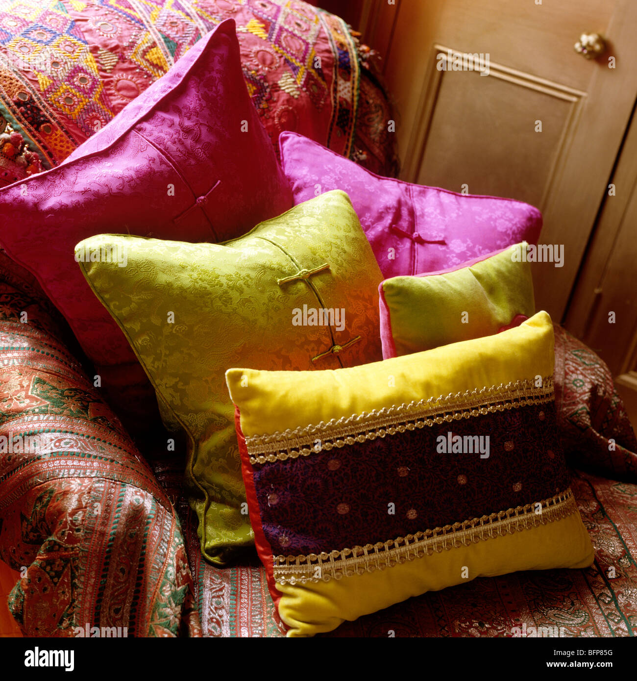 Sofa with Indian cover and bright silk cushions Stock Photo