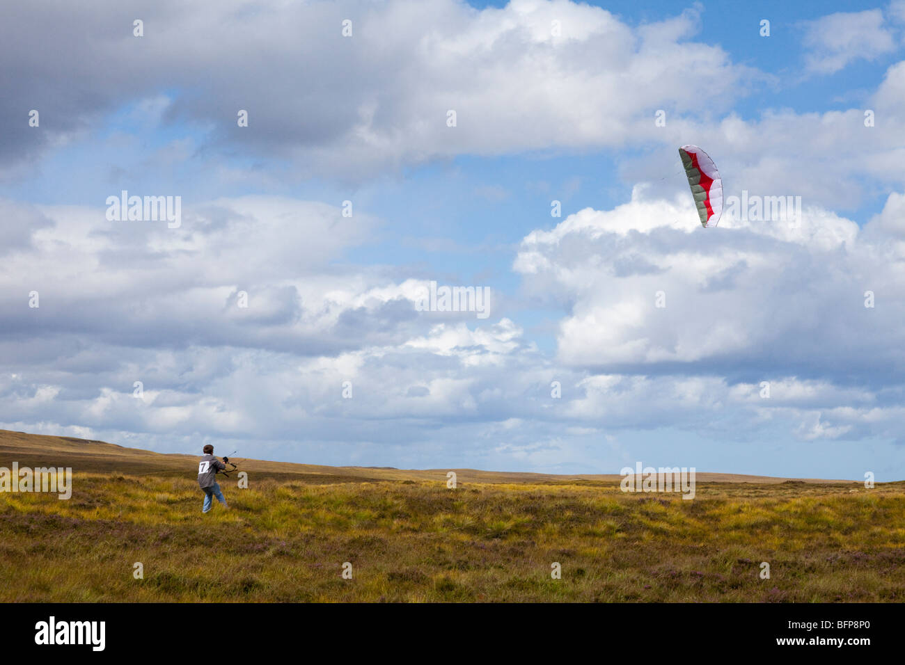 12 year old boy flying a power kite in high winds on moorland east of Syre, Sutherland, Highland, Scotland Stock Photo