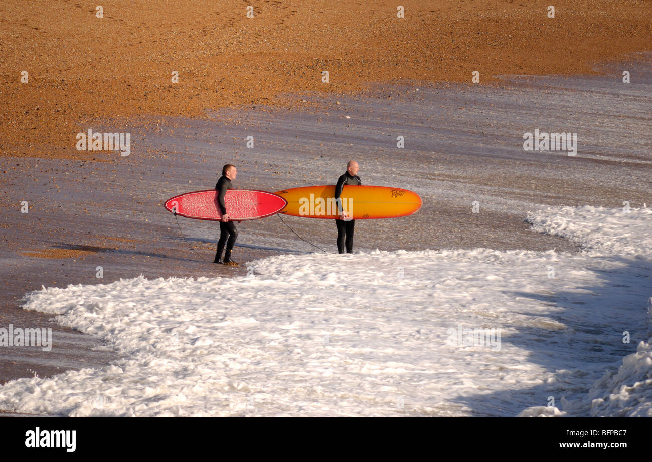 Two surfers contemplate entering the sea Stock Photo