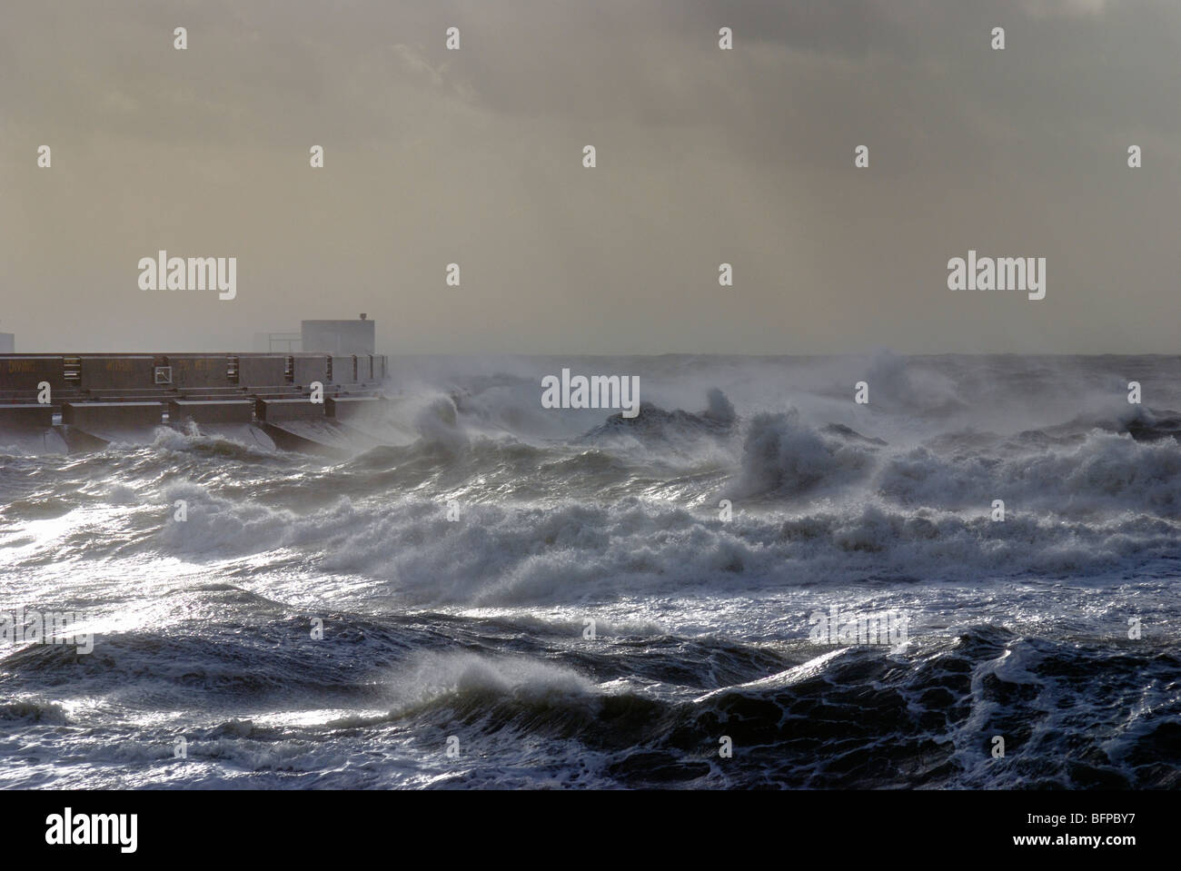 Waves in a stormy sea crash over Brighton marina Stock Photo