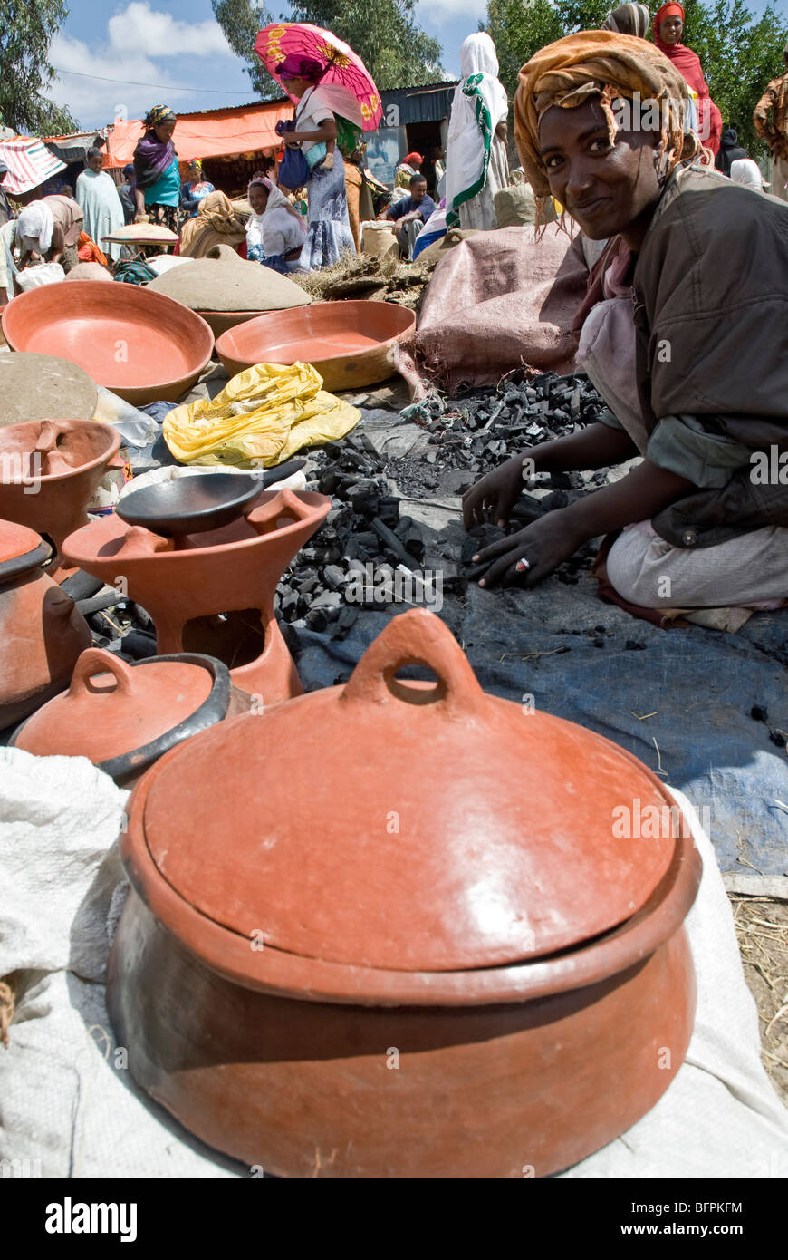 Woman making and selling small bricks of charcoal in a market in