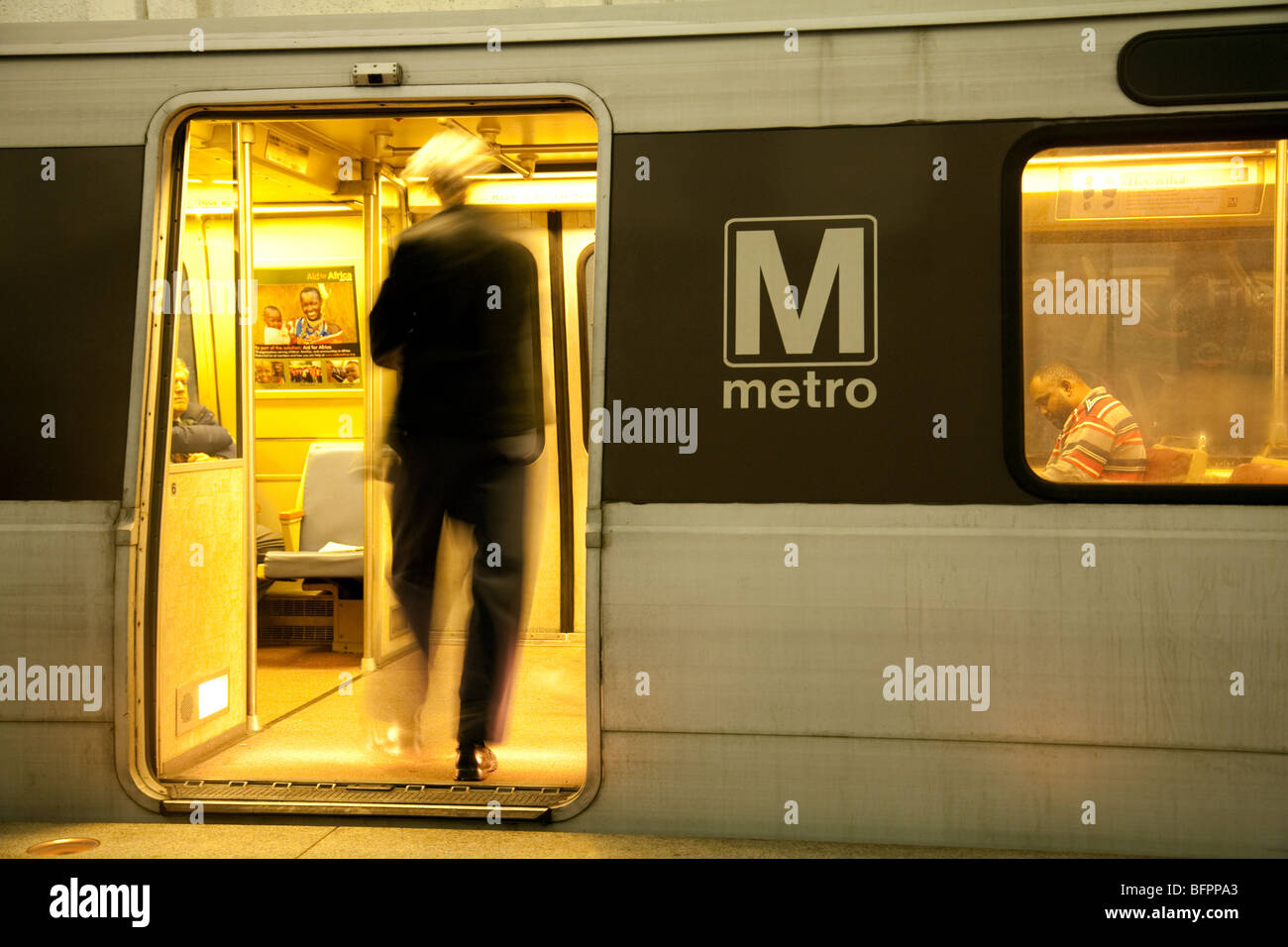 A passenegr getting on a train, the metrorail or metro underground rail