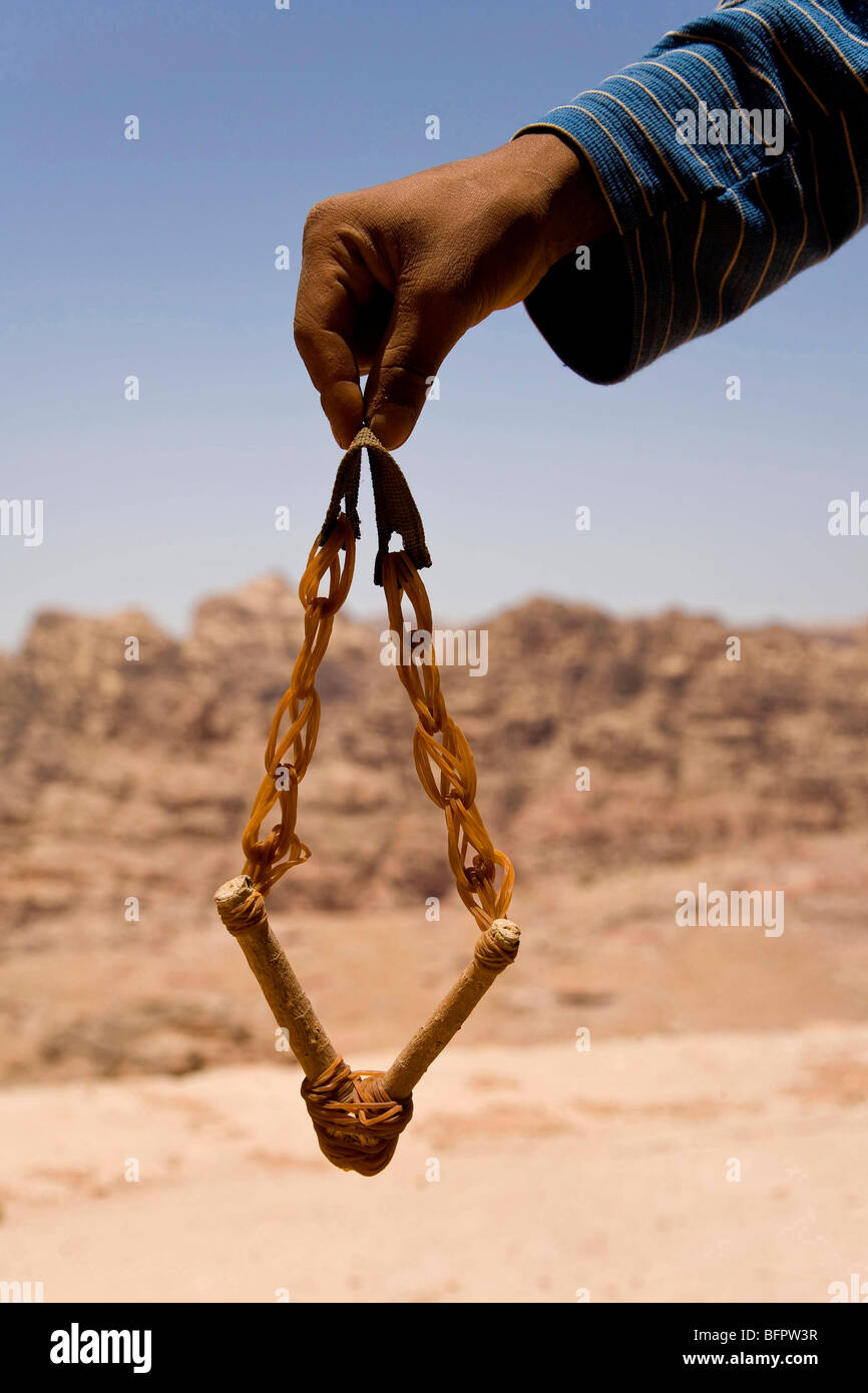 Boy hand holding a slingshot in the desert near Petra, Jordan, Middle