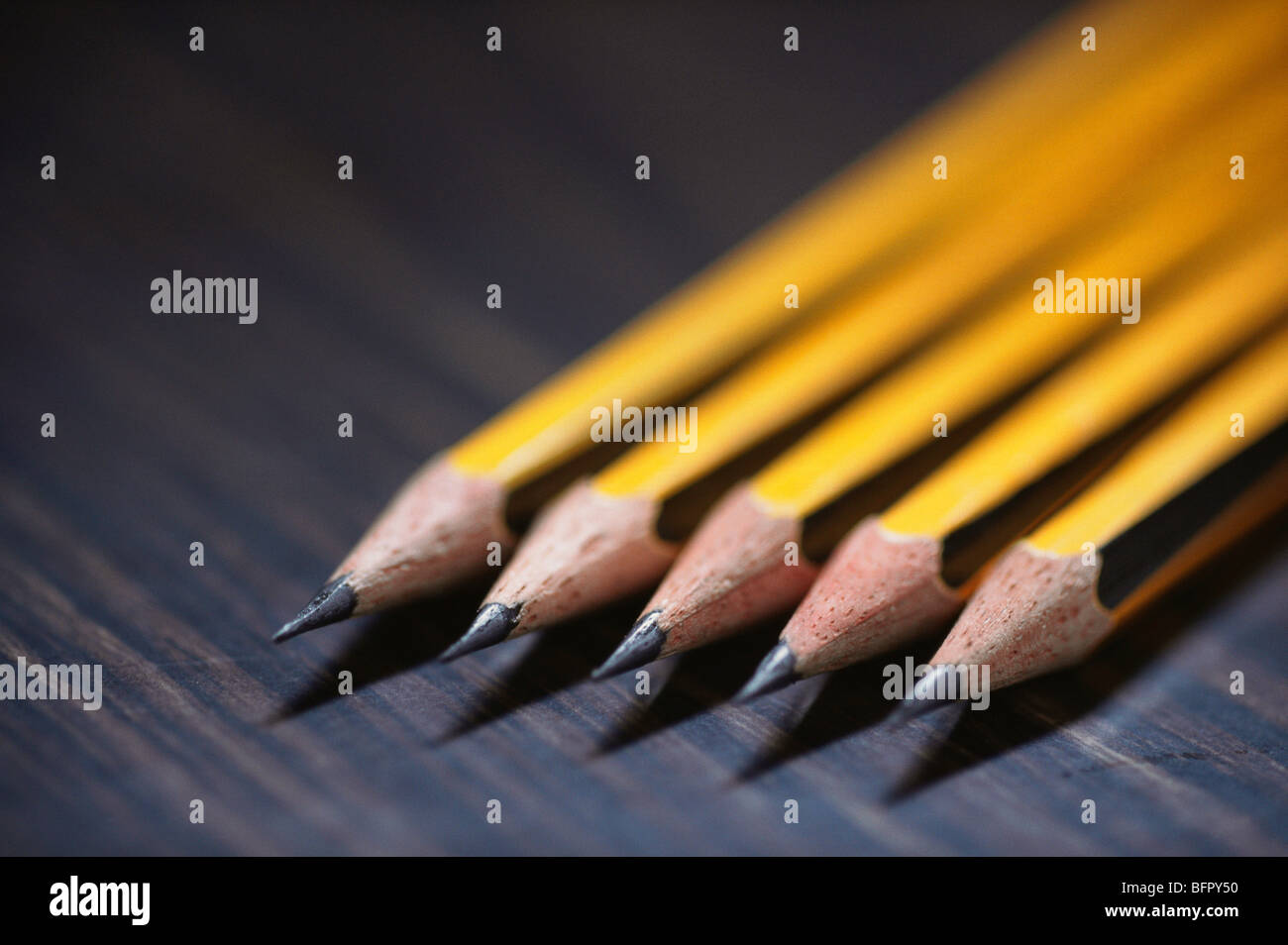 Five pencils, yellow pencils, sharpened pencils on black baackground Stock Photo