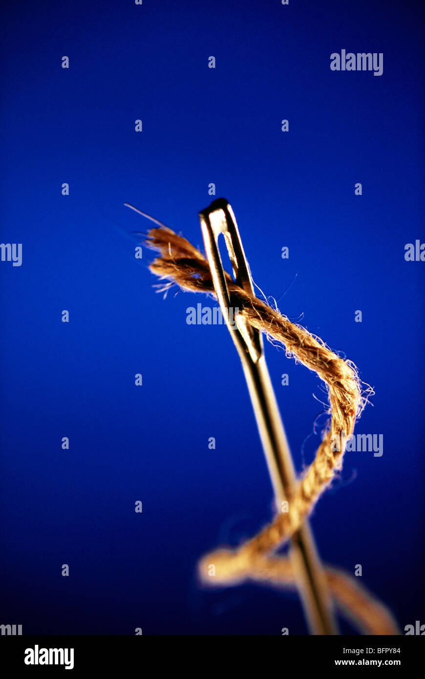 VHM 66703 : Concept ; thread and needle against blue background Stock Photo